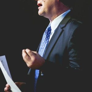 a man in a suit and tie holding a piece of paper